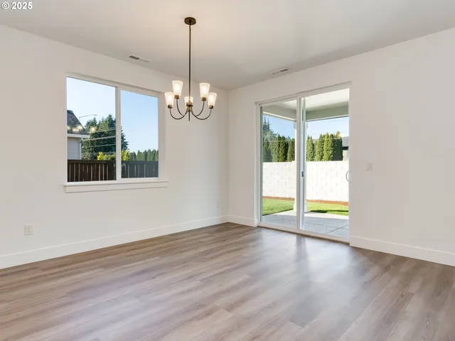 a view of a kitchen with an empty space and wooden floor