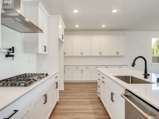 a large kitchen with stainless steel appliances granite countertop a sink and dishwasher with wooden floor