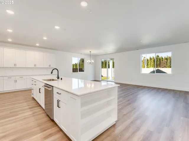 a large white kitchen with a sink and cabinets