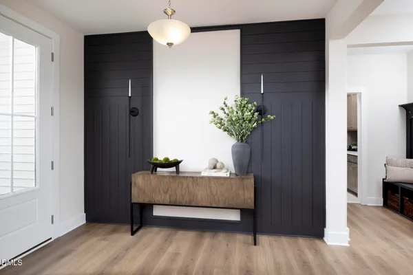 a kitchen with stainless steel appliances kitchen island granite countertop a table chairs refrigerator and microwave