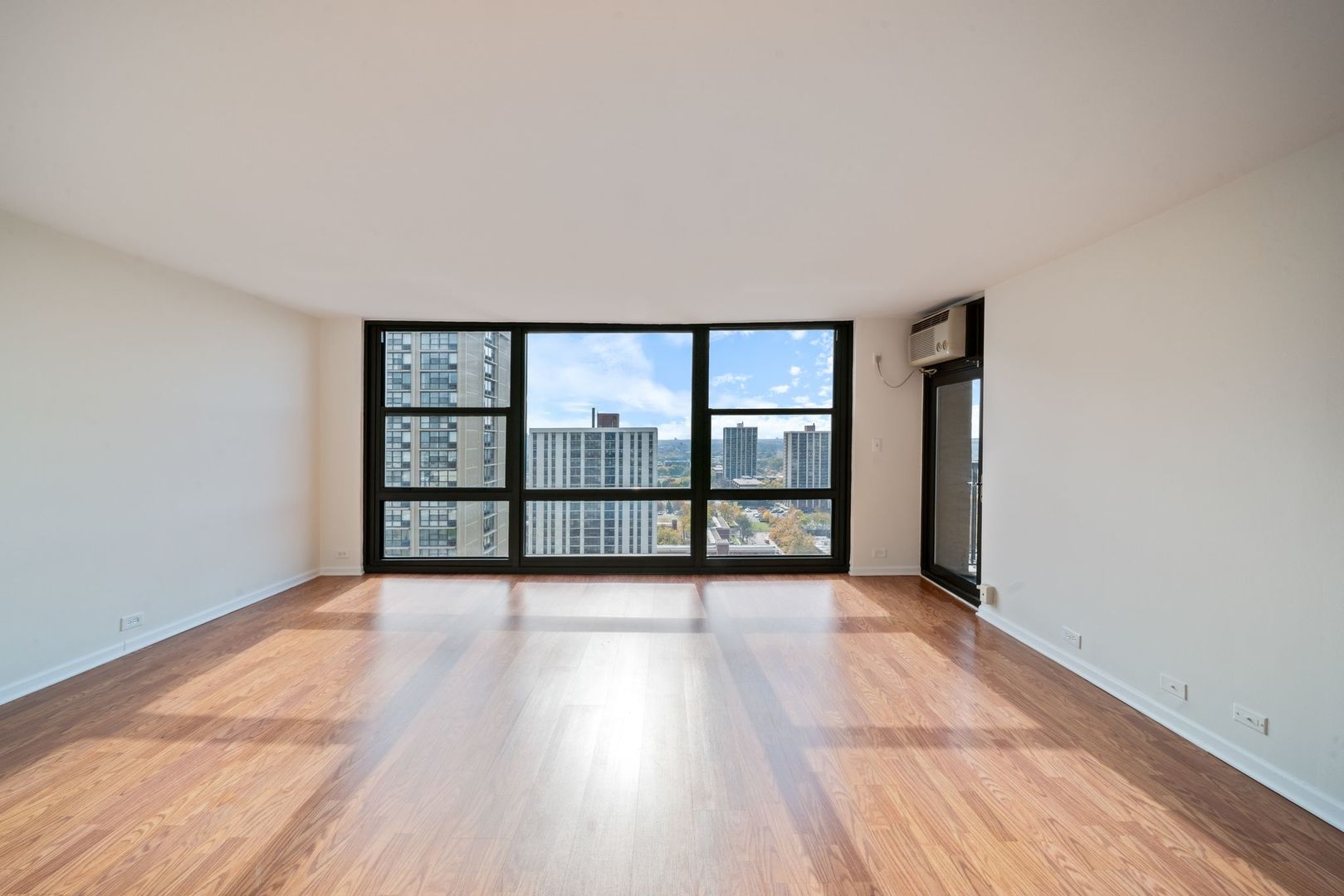 2605 South Indiana Avenue, Unit 2107 Chicago, IL 60616 - Photo 7 of 24 wooden floor in an empty room with a window
