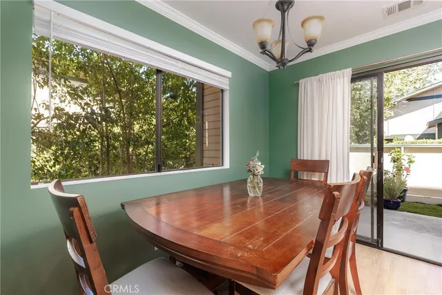 a dining room with furniture window and wooden floor