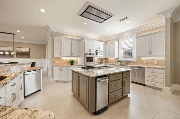 a kitchen with stainless steel appliances granite countertop a stove and cabinets