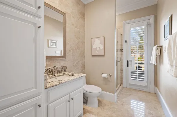 a bathroom with a granite countertop toilet a sink and a mirror