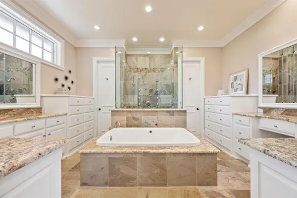 a spacious bathroom with sinks mirror and a bathtub