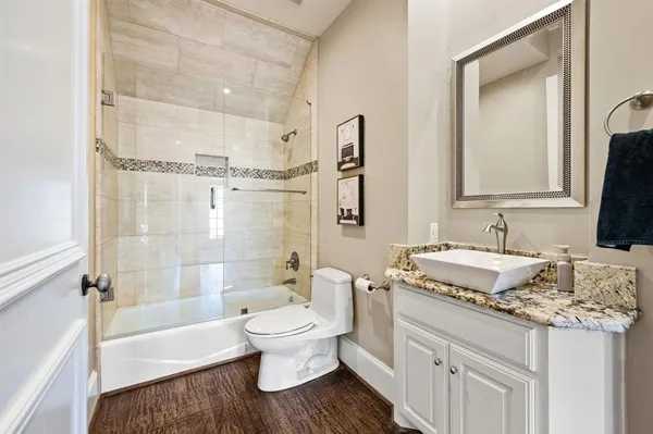a bathroom with a granite countertop sink toilet and shower