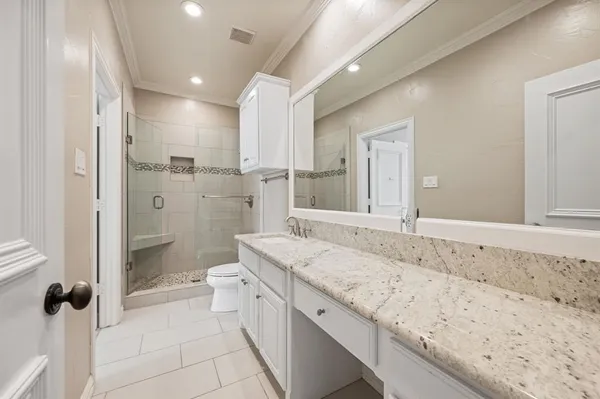 a bathroom with a granite countertop sink mirror and shower