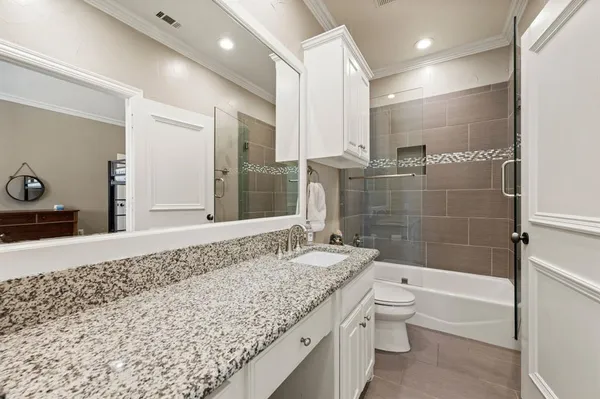 a bathroom with a granite countertop sink a toilet and bathtub