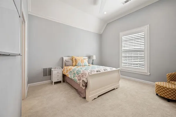 a bed sitting in a bedroom next to a window