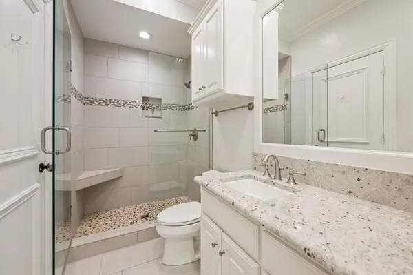 a bathroom with a sink a toilet and shower