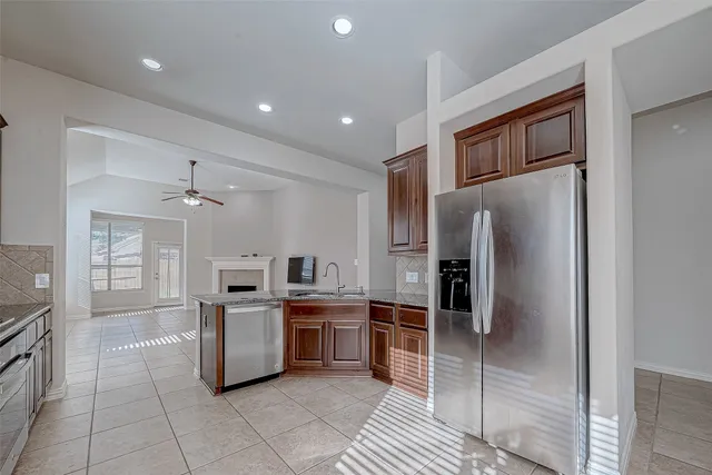 a kitchen with stainless steel appliances granite countertop a sink and dishwasher a stove top oven with wooden floor