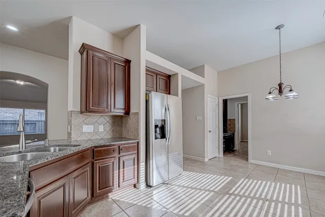 a kitchen with stainless steel appliances granite countertop a sink and cabinets with wooden floor