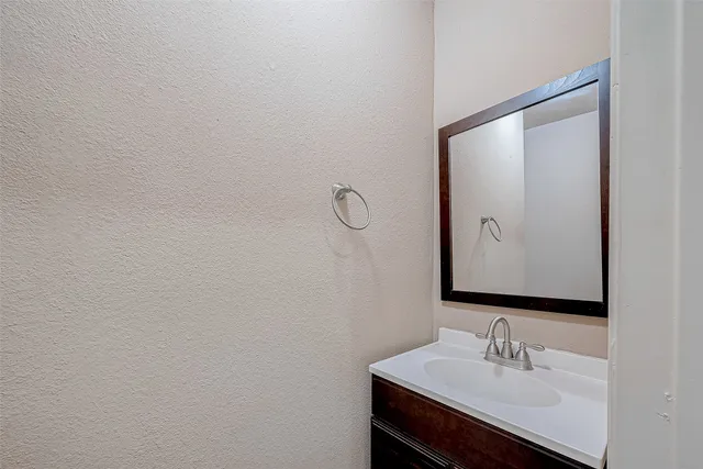 an empty room with a window and a chandelier fan