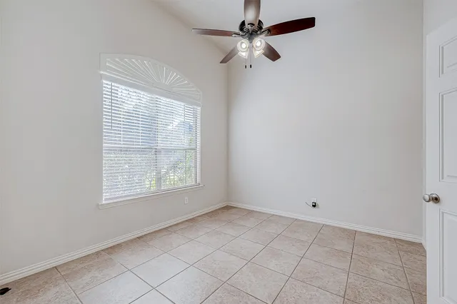 an empty room with windows and fan