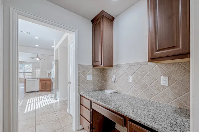 a view of an empty room with window and chandelier fan