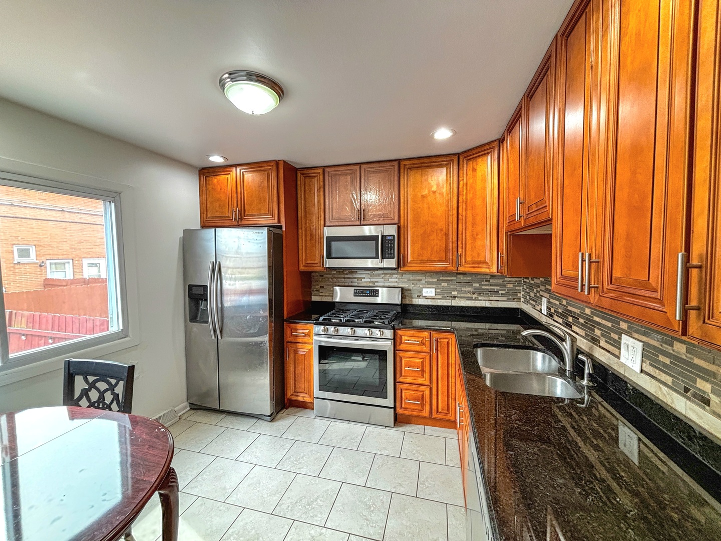 8664 Gregory Lane, Unit E Des Plaines, IL 60016 - Photo 4 of 15 a kitchen with stainless steel appliances granite countertop a refrigerator and a sink