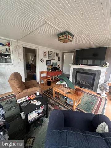 a living room with furniture a flat screen tv and kitchen view