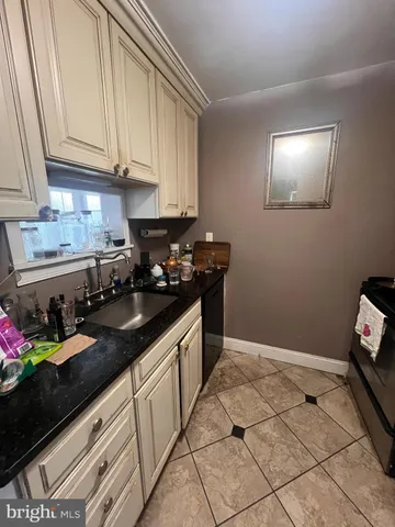 a kitchen with granite countertop a sink a stove and cabinets