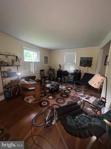 a living room with furniture hard wood floor and a rug