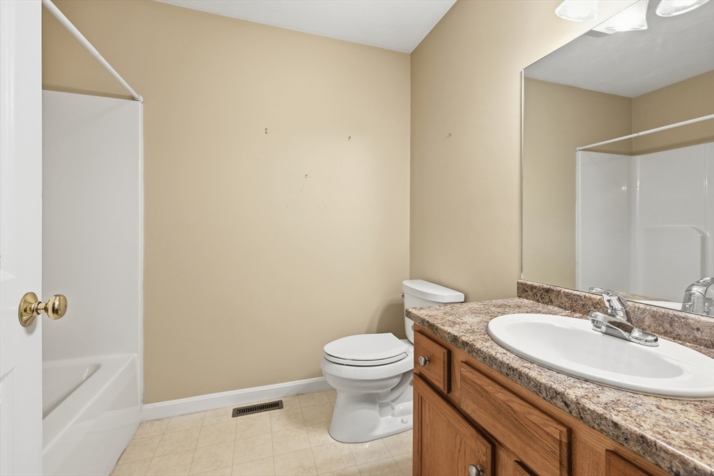 9 Rock Marsh Road, Unit B Wareham, MA 02571 - Photo 21 of 41 a bathroom with a granite countertop sink a toilet and a mirror