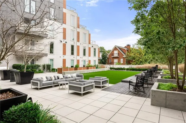 a view of a patio with table and chairs potted plants and a big yard