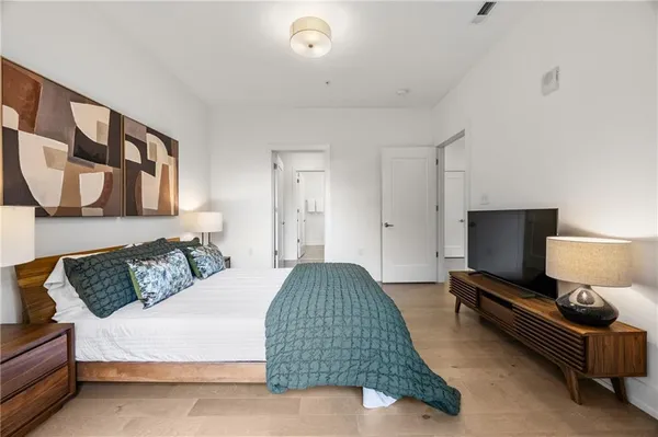 a bedroom with a bed couch and a flat tv screen