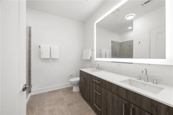a bathroom with a double vanity sink toilet and mirror