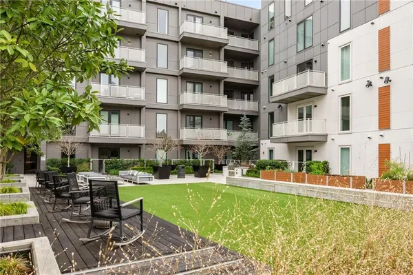 a view of a building with a yard and sitting area