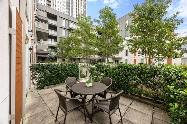 a view of a patio with a table and chairs and a large tree