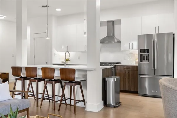 a kitchen with stainless steel appliances granite countertop a refrigerator a stove a sink and a dining table