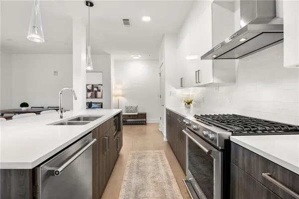 a kitchen with stainless steel appliances a sink stove and cabinets