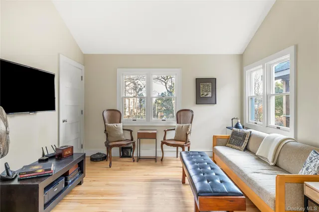 a living room with furniture a flat screen tv and a window