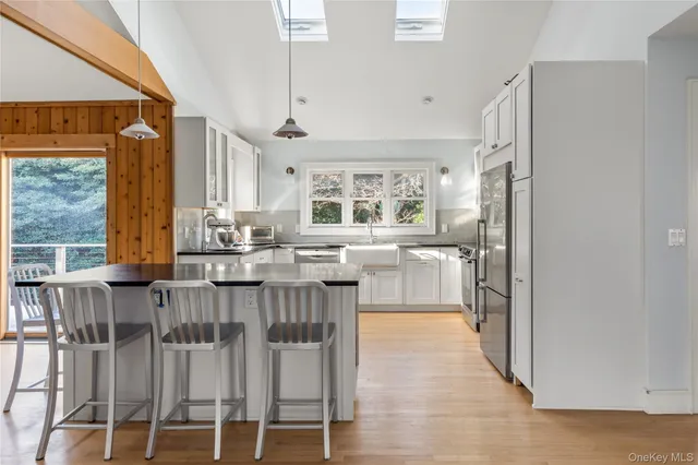 a kitchen with stainless steel appliances kitchen island granite countertop a dining table chairs and granite counter tops