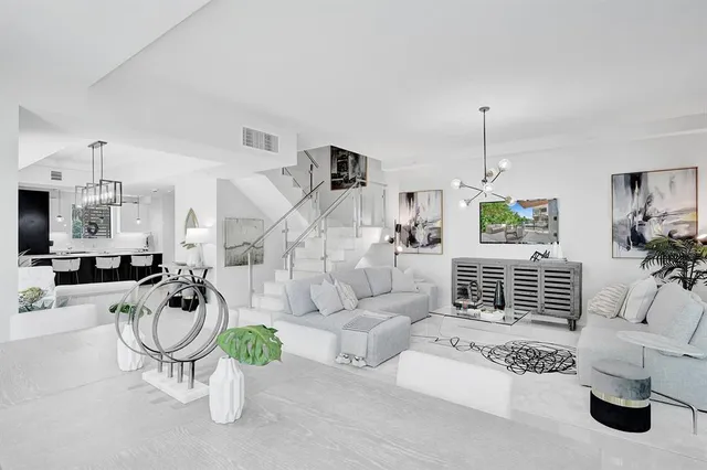 a living room with furniture a couch and a chandelier