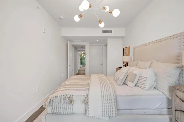 a bedroom with a large bed and a chandelier