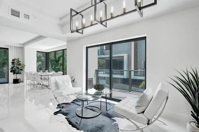 a living room with furniture a floor to ceiling window and dining table