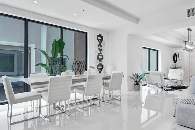 a living room with furniture a potted plant and a large window