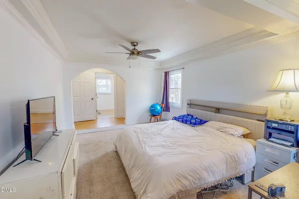 a bedroom with a large bed and a chandelier