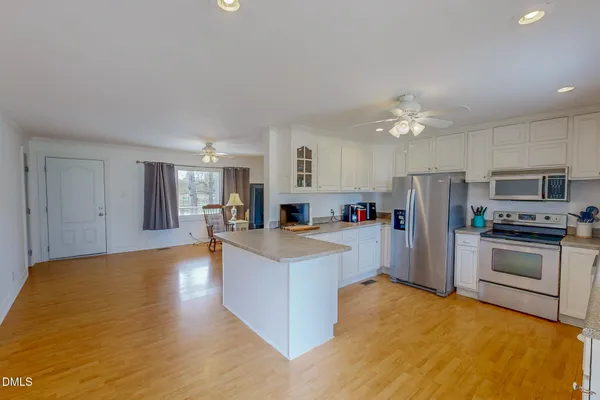 a view of kitchen with furniture a refrigerator and a fireplace