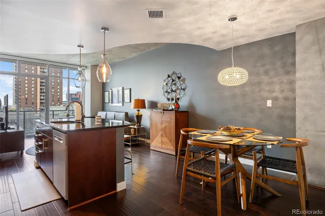 a kitchen with stainless steel appliances kitchen island granite countertop a table chairs and a refrigerator