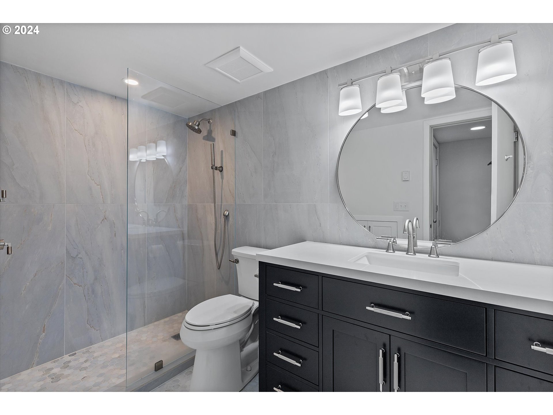 3427 Southwest Dosch Road Portland, OR 97239 - Photo 29 of 48 a bathroom with a toilet a sink a mirror and a shower