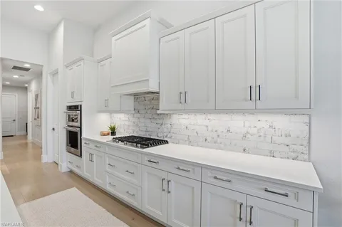 a kitchen with granite countertop white cabinets and white appliances