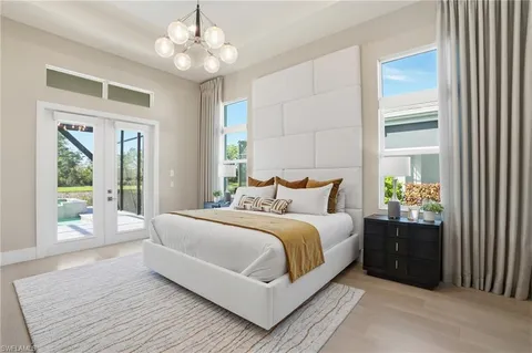 a bedroom with a large bed and a chandelier fan