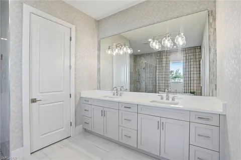 a bathroom with double vanity and a mirror