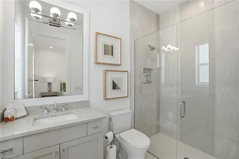 a bathroom with a granite countertop sink a toilet and shower