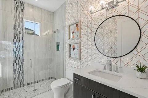 a bathroom with a sink a mirror a toilet and a shower