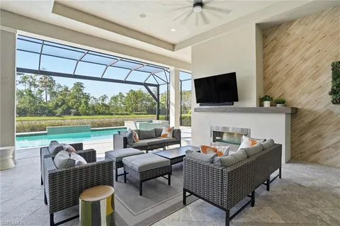 a living room with furniture a flat screen tv and a floor to ceiling window