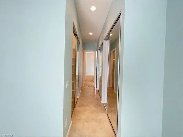a view of a hallway with wooden shelves