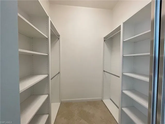 a view of walk in closet with empty racks