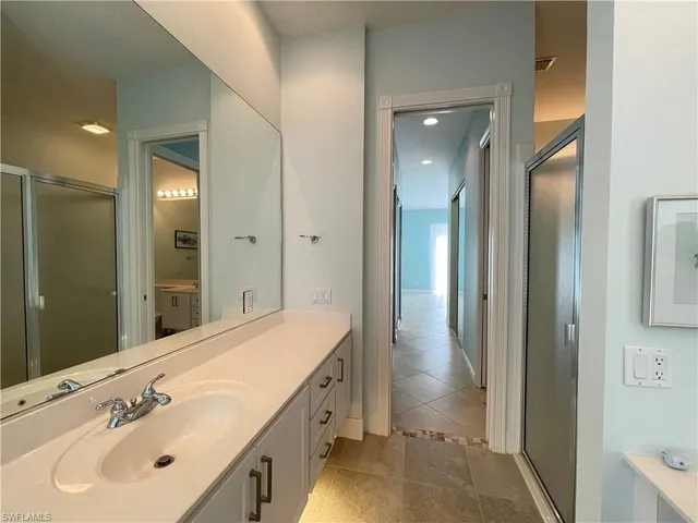 a bathroom with a sink a mirror and a shower